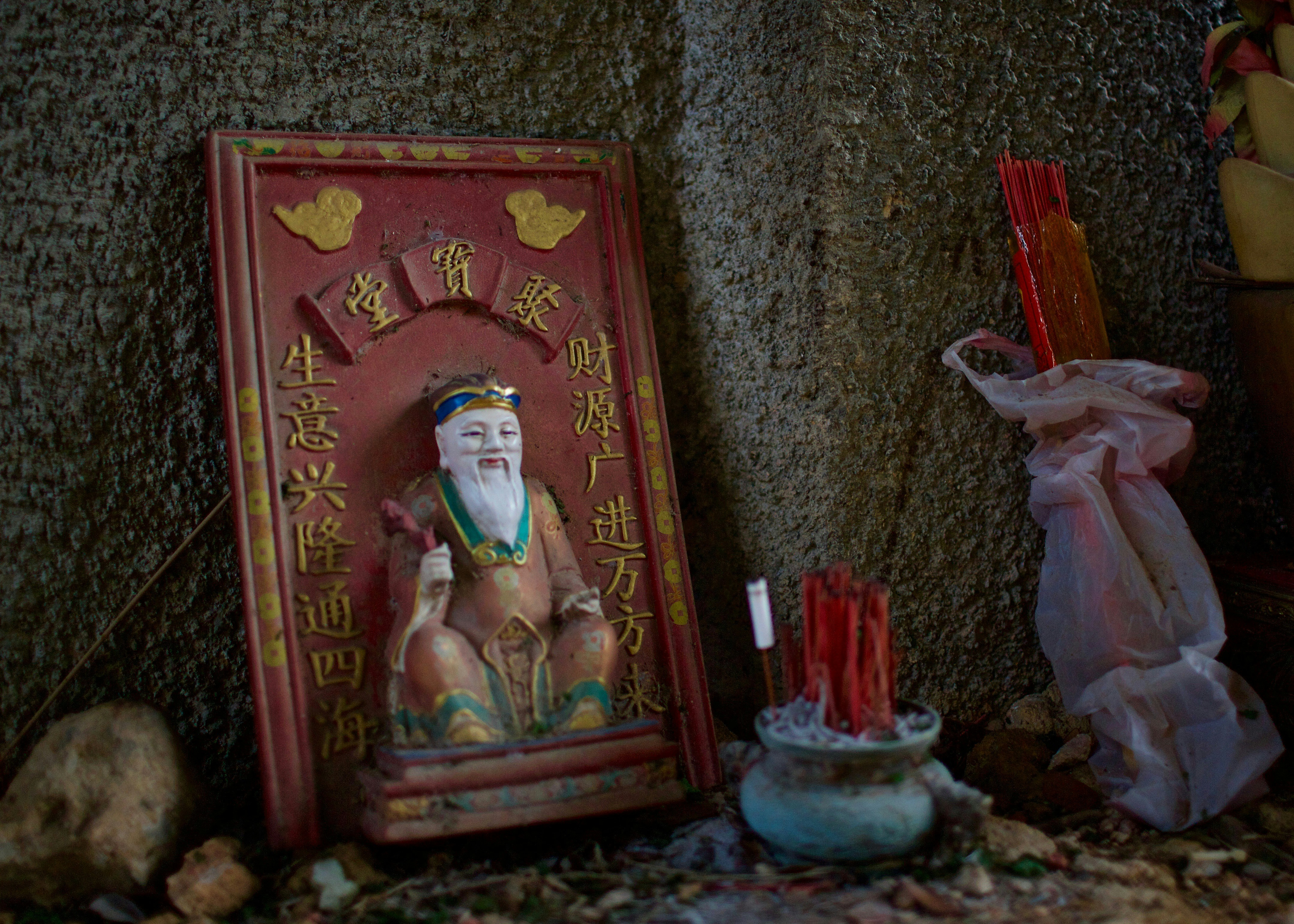 a statue of a man with a beard next to some candles