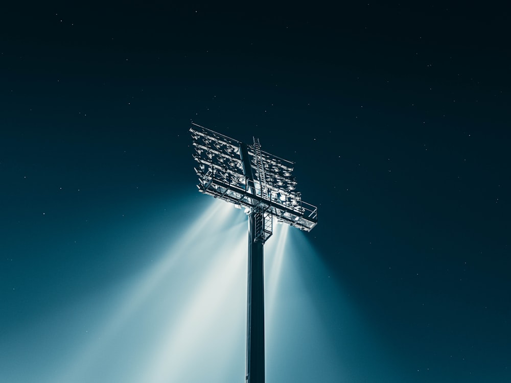 a stadium sign with lights shining down on it