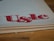 Large, stylized red lettering 'U&lc' on the corner of a page, with the edge of a book in the foreground and a wooden surface underneath.