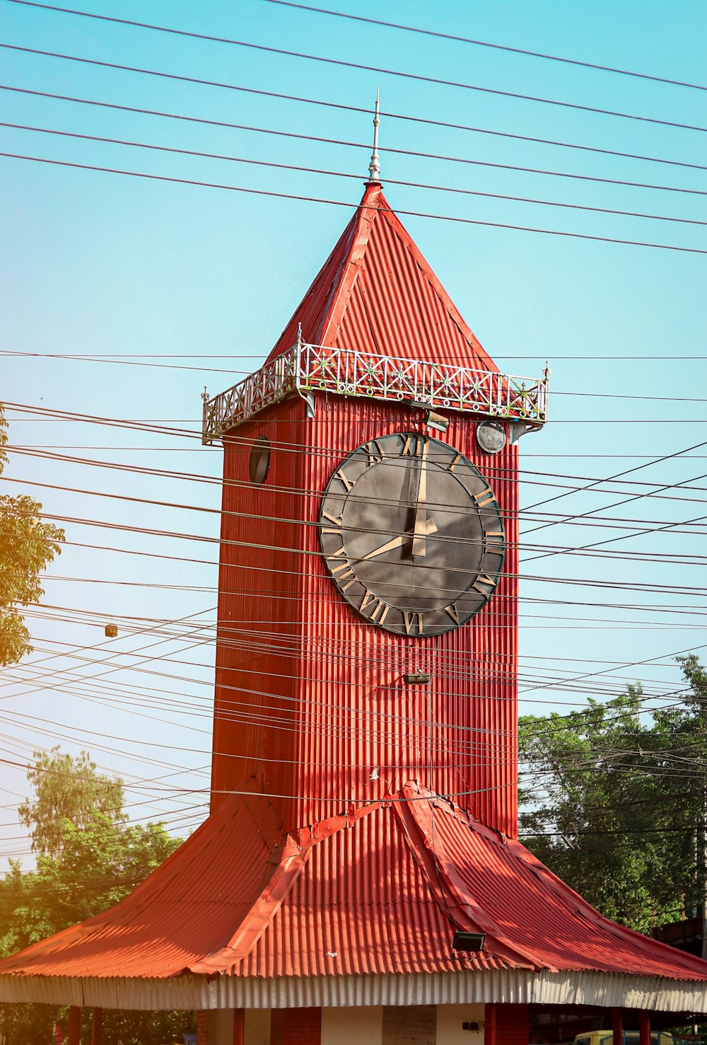 a large red clock tower with a red roof
