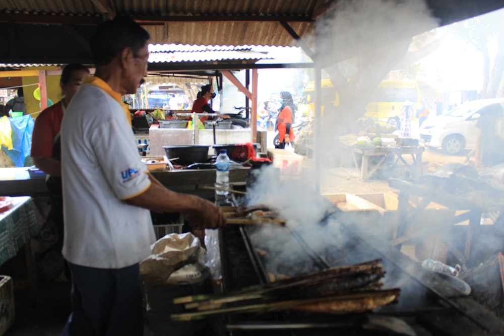 a man cooking food on top of a grill