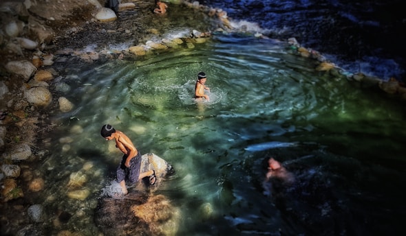 Children enjoying therapy in a warm saltwater pool surrounded by nature.