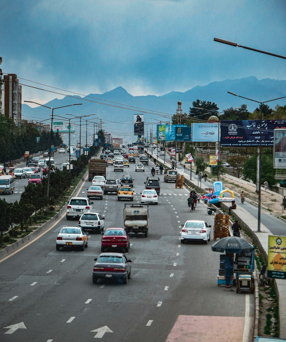 a city street filled with lots of traffic under a cloudy sky