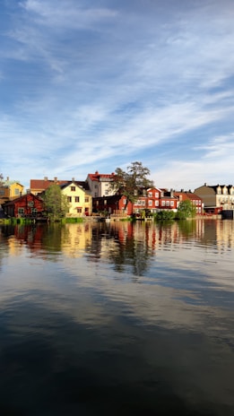 A vibrant view of Guatapé's colorful waterfront houses reflecting in the calm lake at sunset.