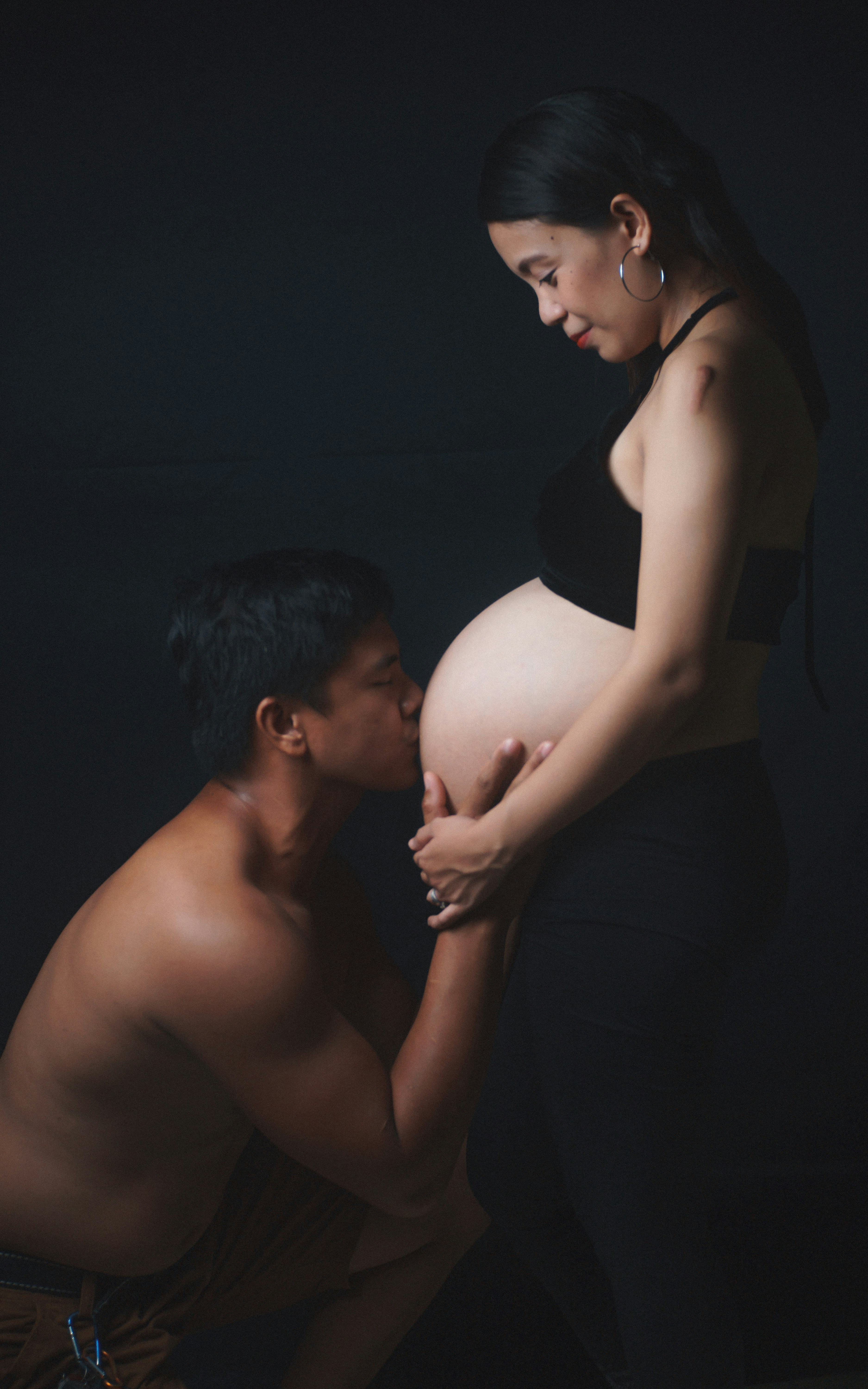 A pregnant man and a pregnant woman posing for a photo photo photo pic