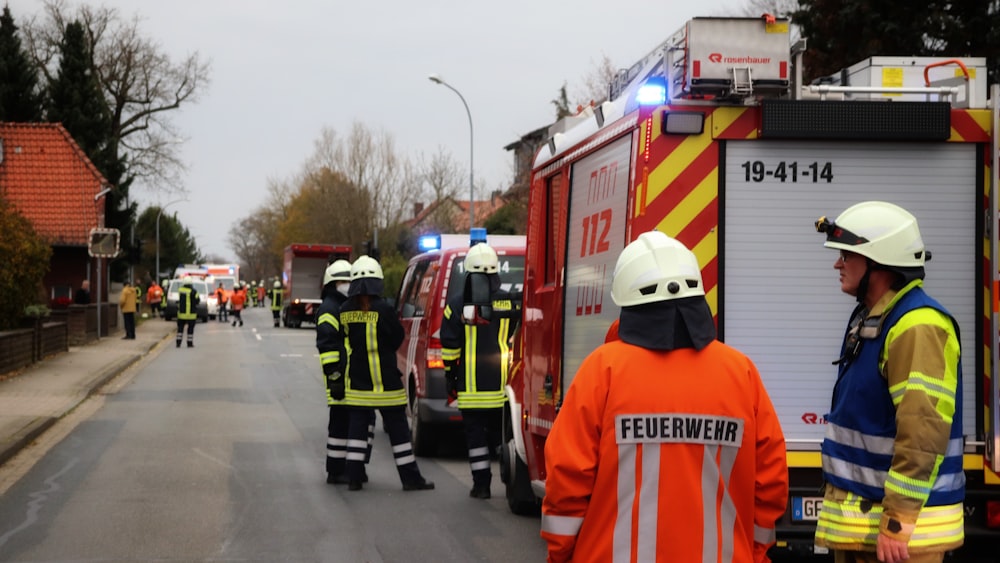 a group of fire fighters standing next to a fire truck