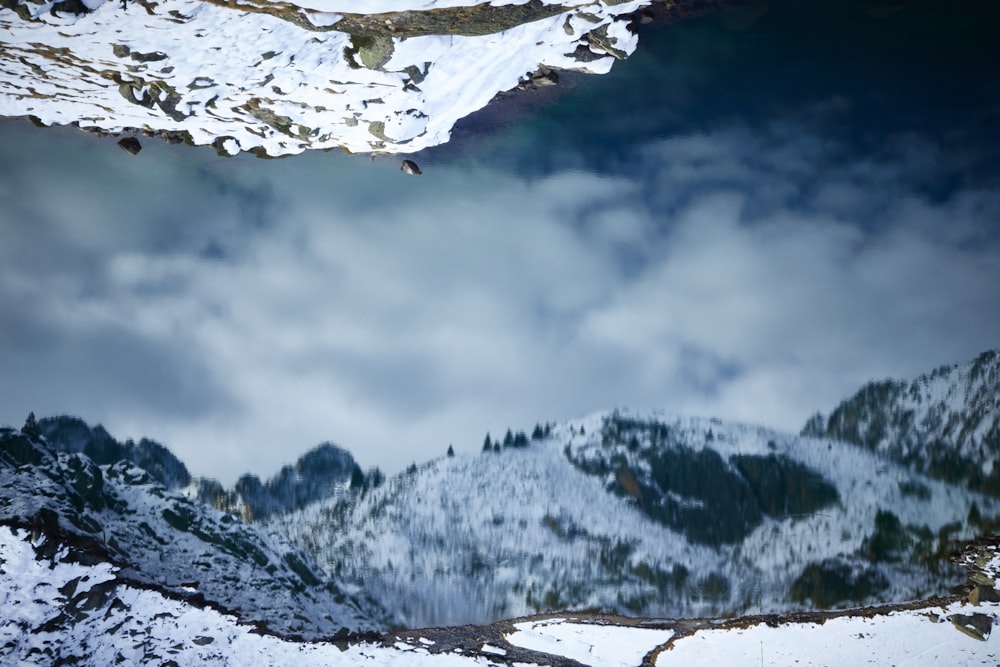 a snow covered mountain with a lake below