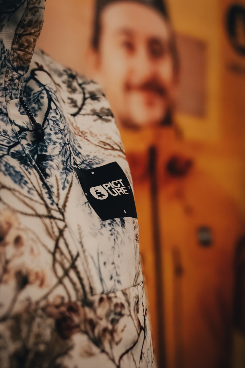 a close up of a shirt with a picture of a man in the background
