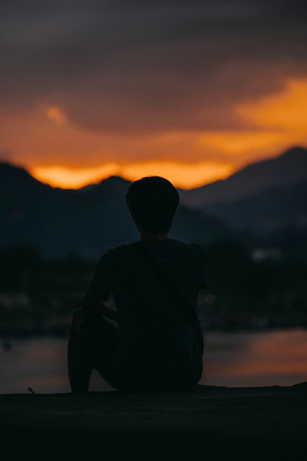 a person sitting on a beach watching the sunset