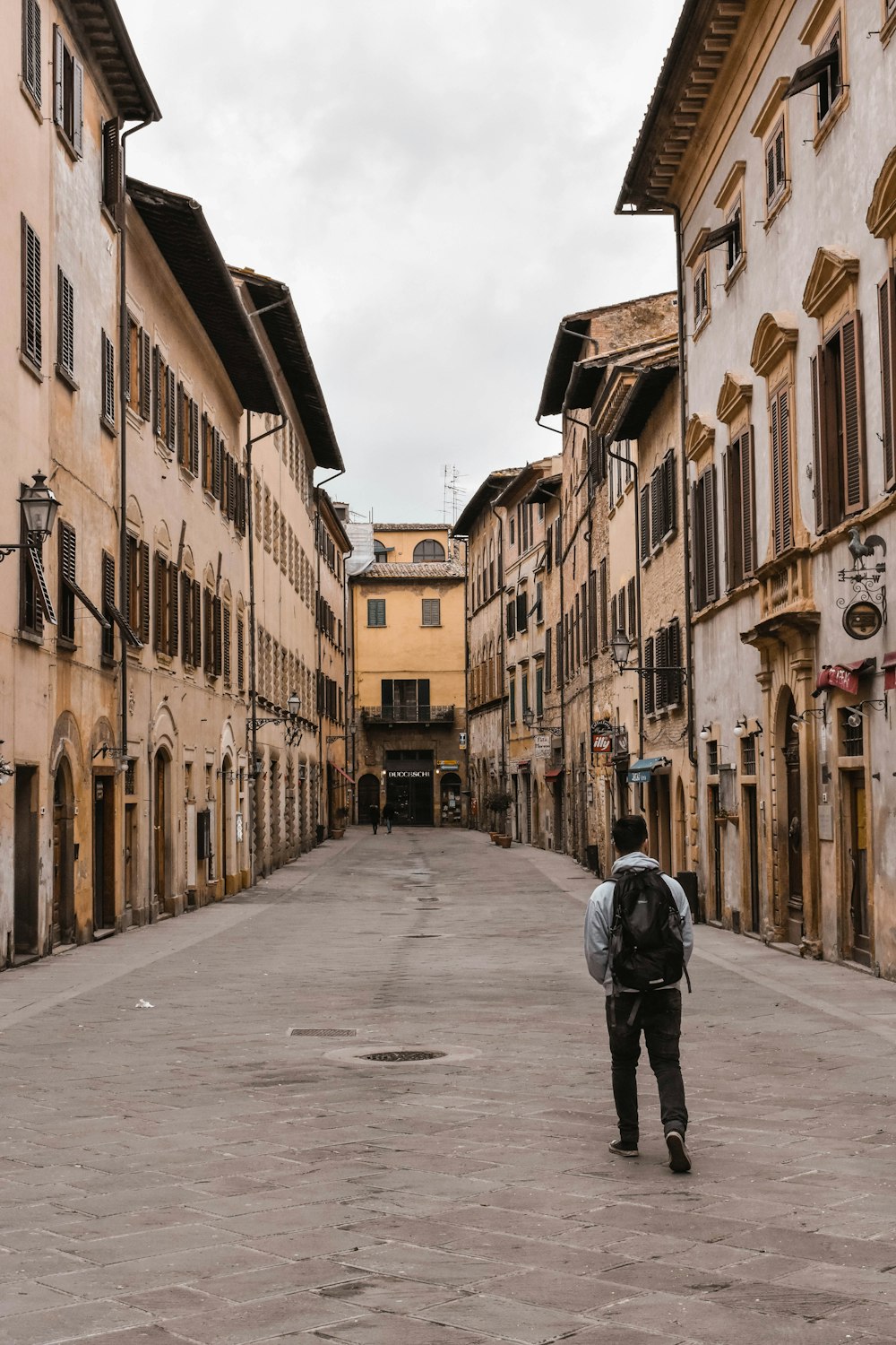 a man with a backpack walking down a street