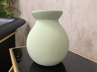 Elegant 3D printed vase in deep green with gold highlights on a wooden table.
