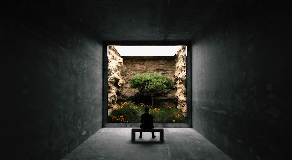 a person sitting on a bench in a dark room