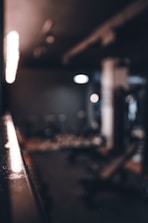 Trainer guiding a client through a focused workout in a warm, earthy-toned gym.