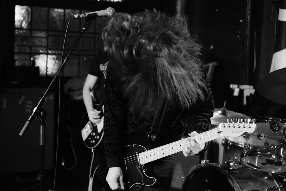 a man with long hair playing a guitar