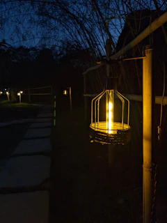 Outdoor garden lanterns glowing gently along a stone pathway at dusk.