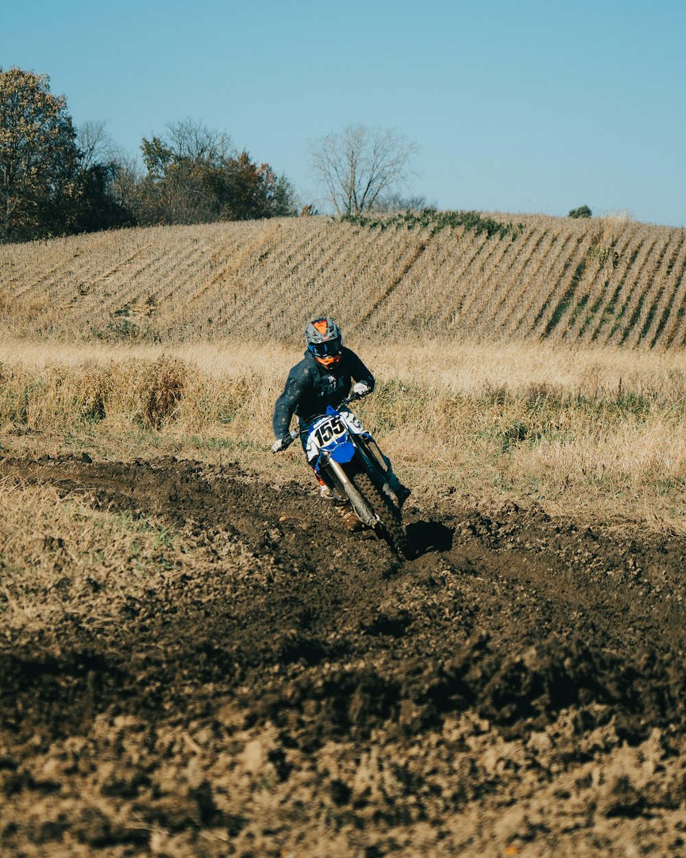 a man riding a dirt bike on top of a dirt field