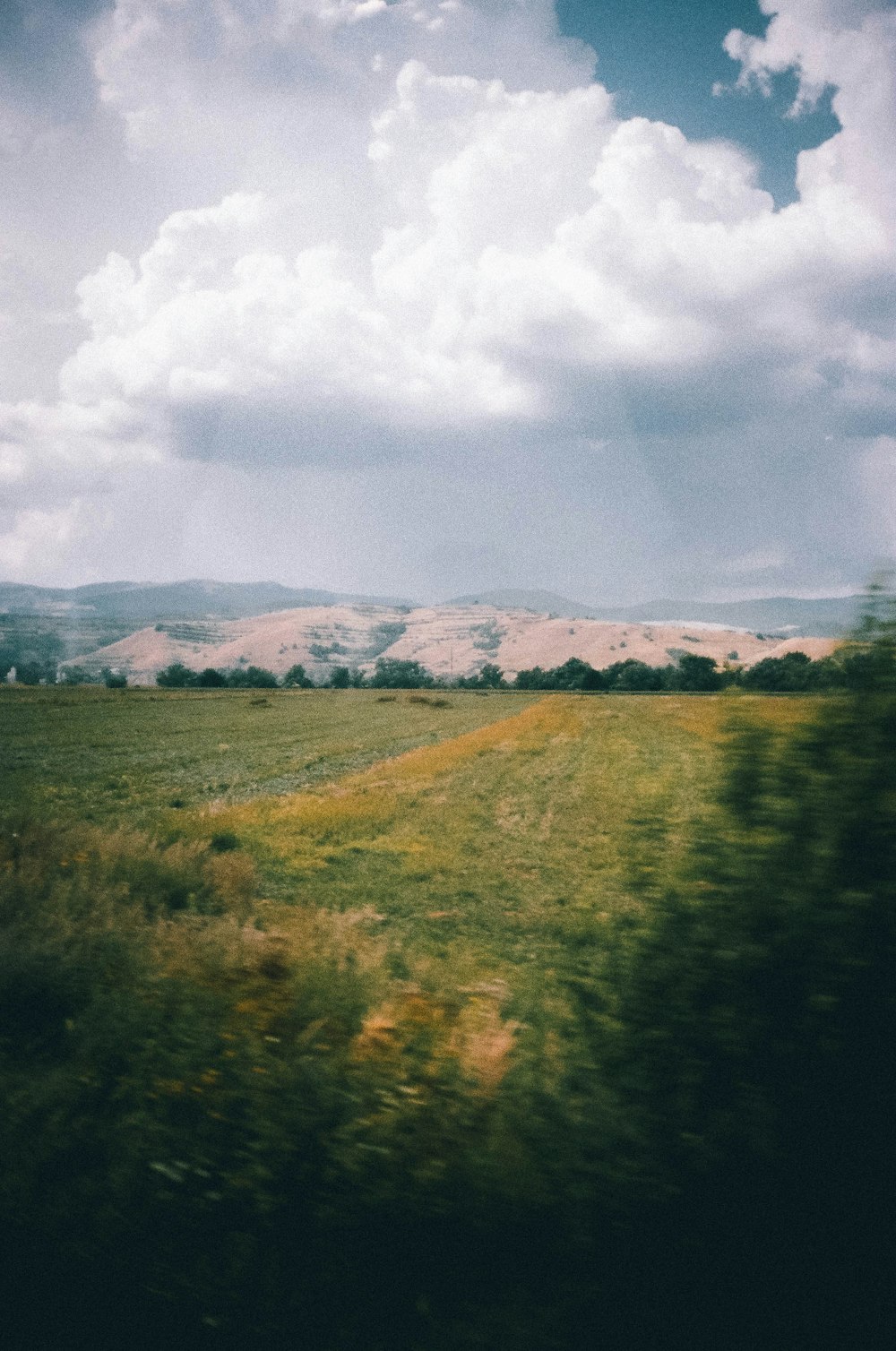 a grassy field with mountains in the distance