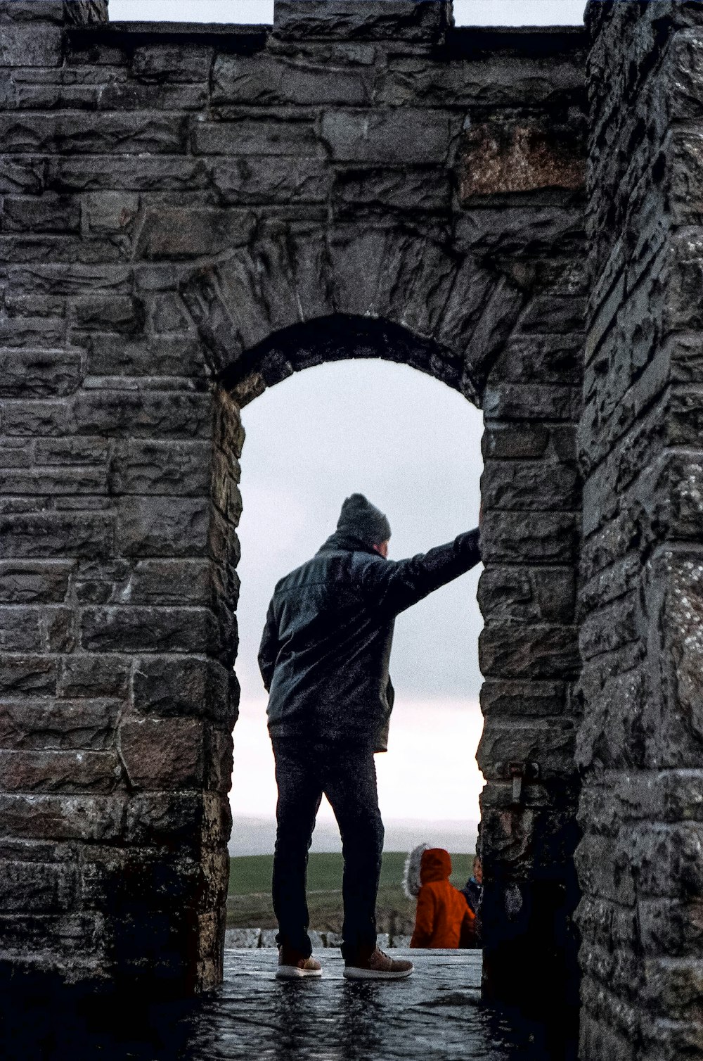 a man is standing in a stone archway