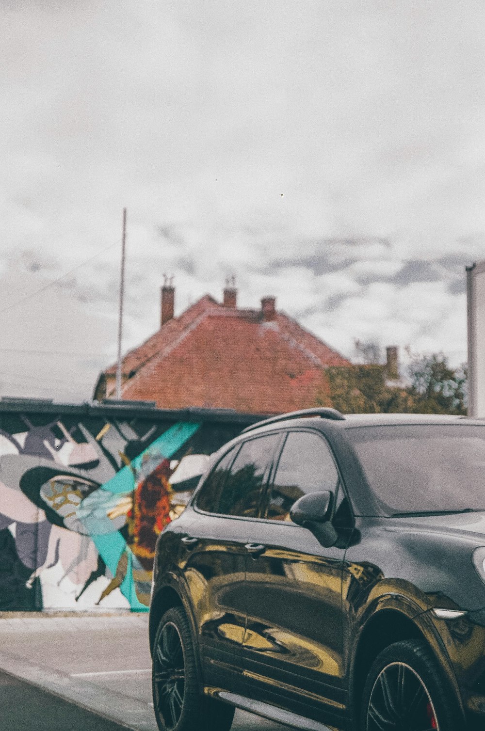 a black porsche cayen is parked on the side of the road