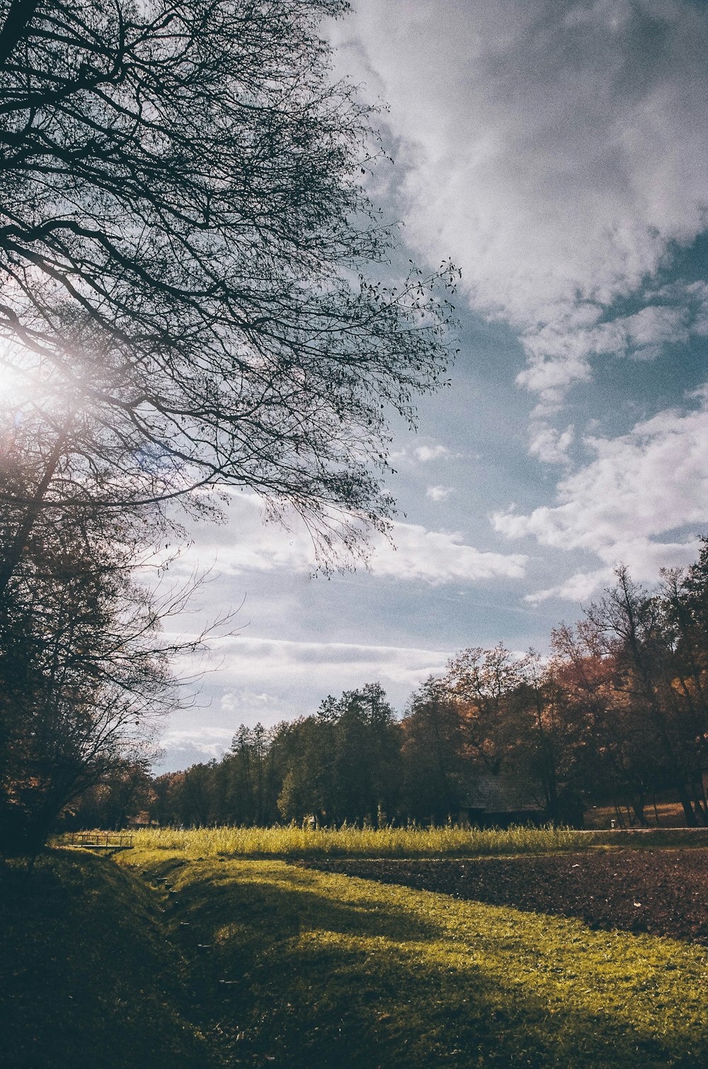 the sun shines through the clouds over a field