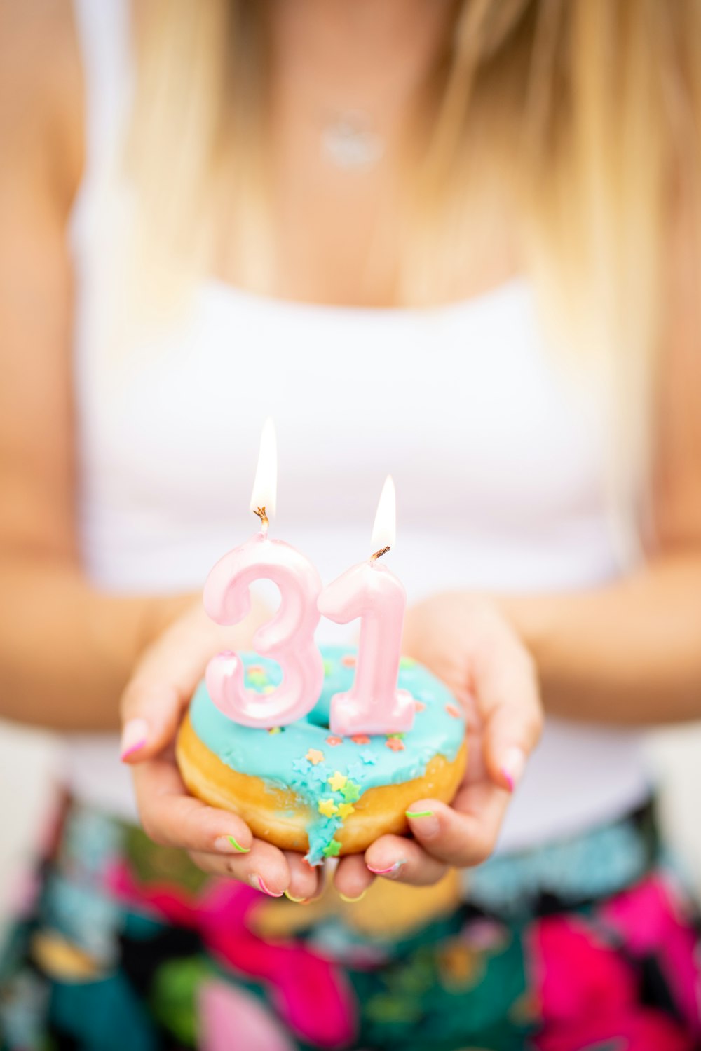 a woman holding a cupcake with candles in it