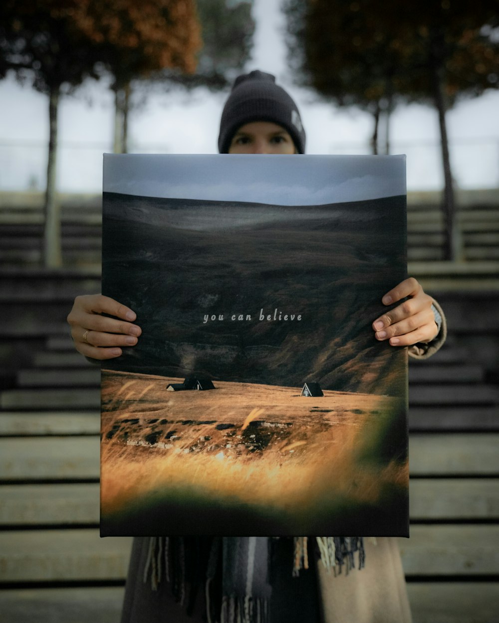 a person holding up a picture of a mountain