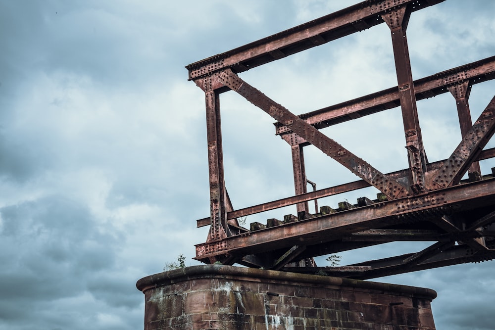 an old rusted metal structure on top of a brick wall