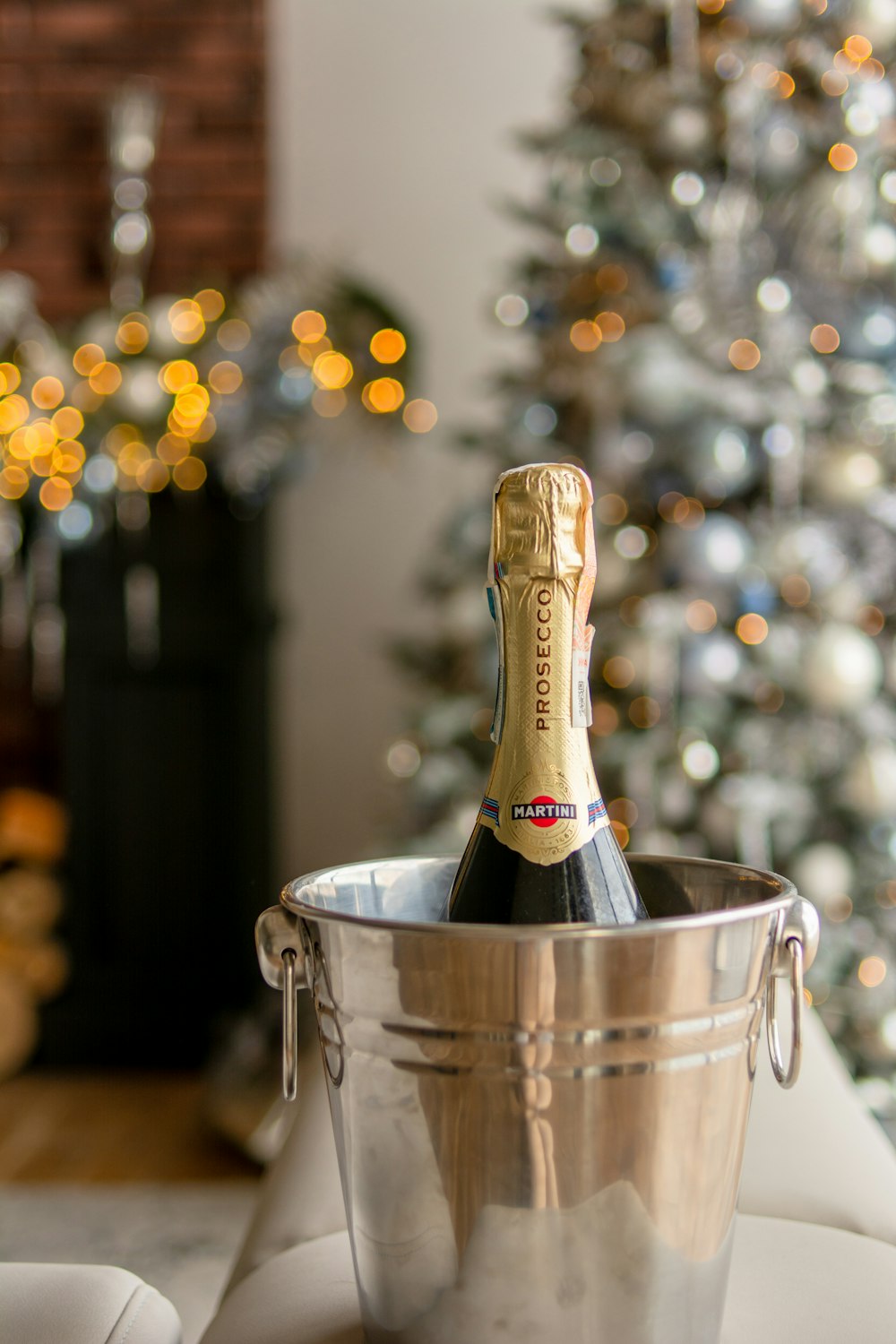 a bottle of champagne in a bucket next to a christmas tree