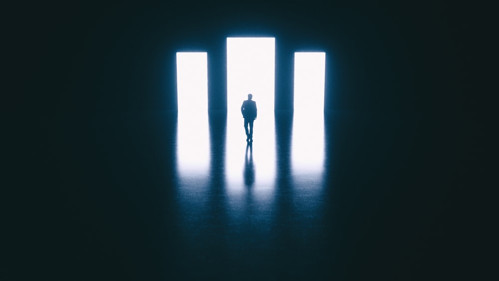Eine Person, die vor einer Tür in einem dunklen Raum steht