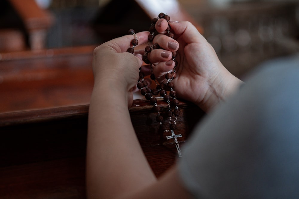 a person holding a rosary in their hands