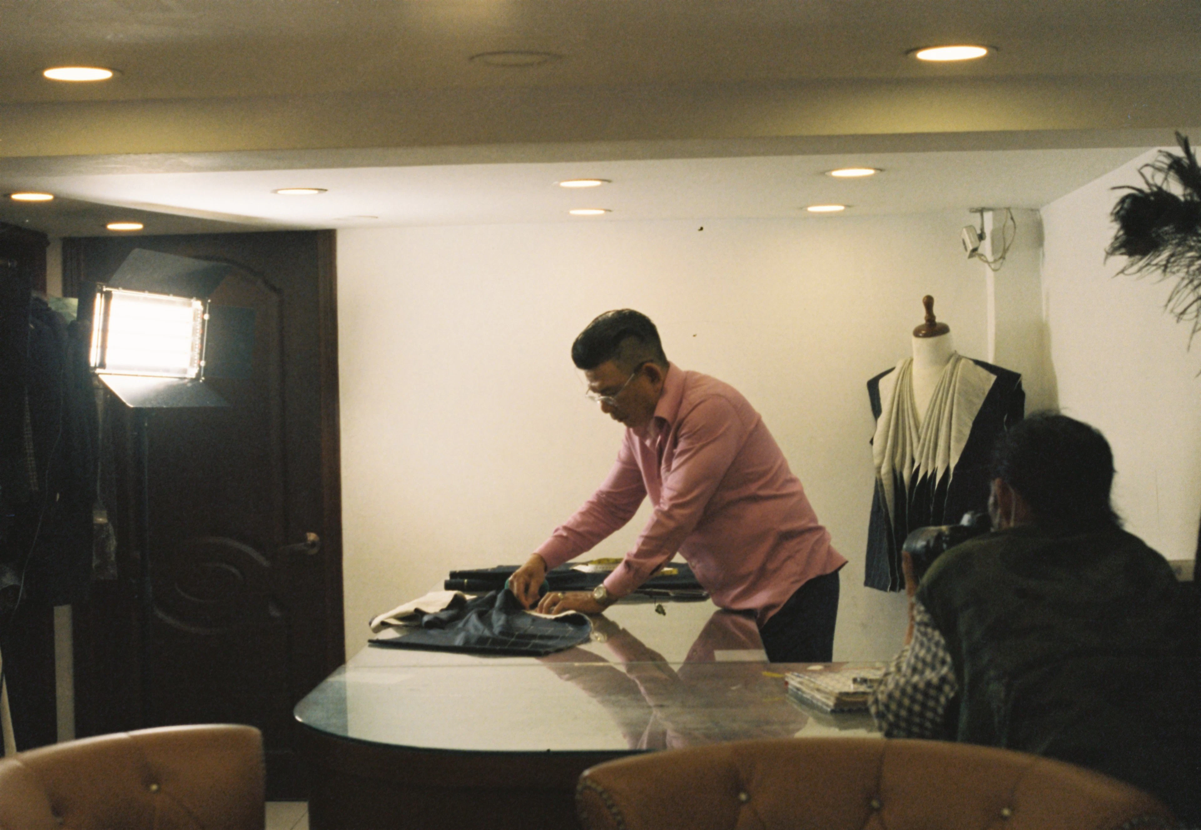 A tailor pressing fabric in his studio