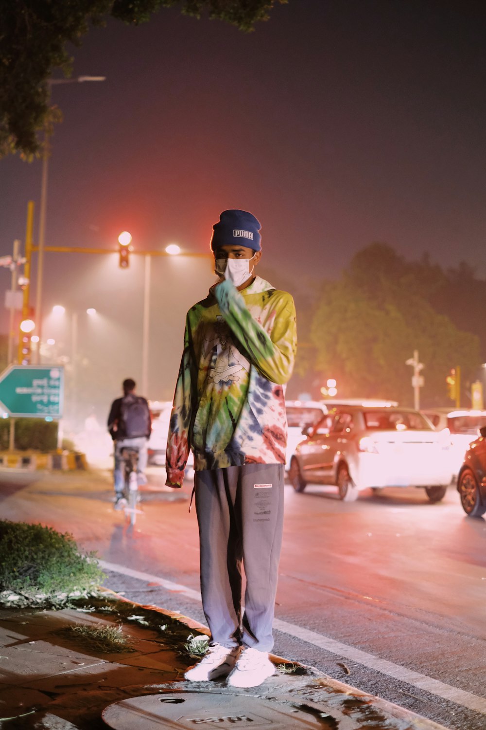 a man standing on the side of a road at night