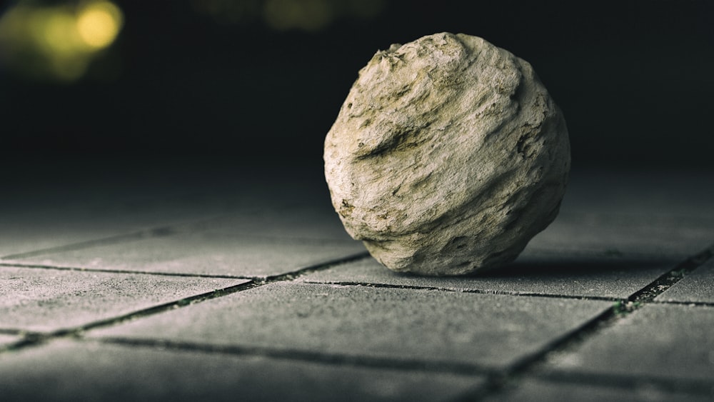 a rock sitting on top of a tiled floor