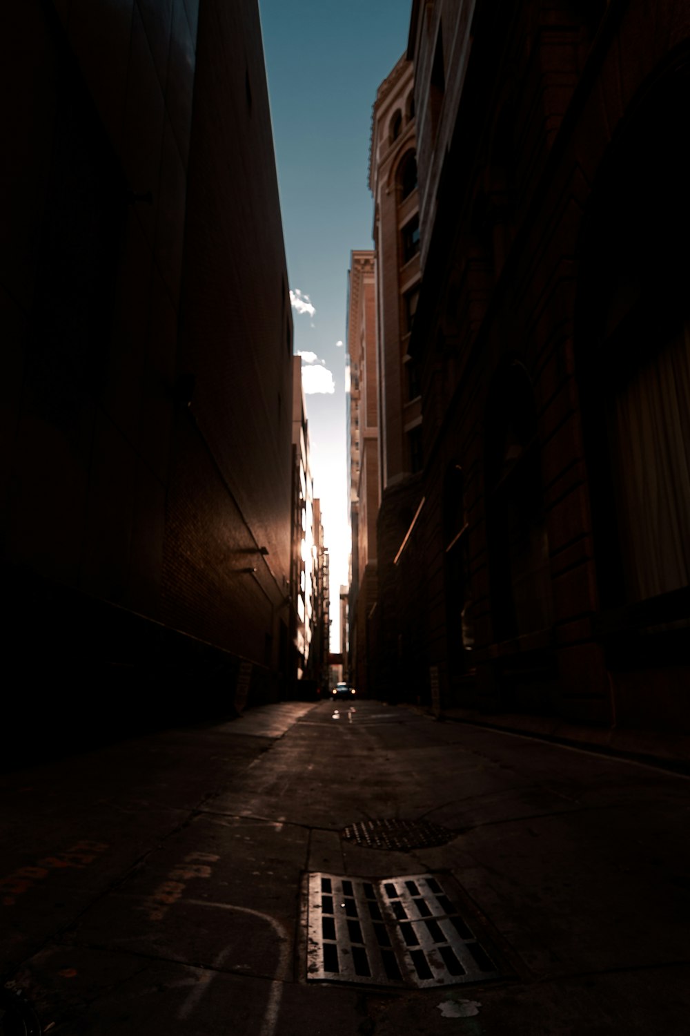 a dark alley way with buildings and a sky background