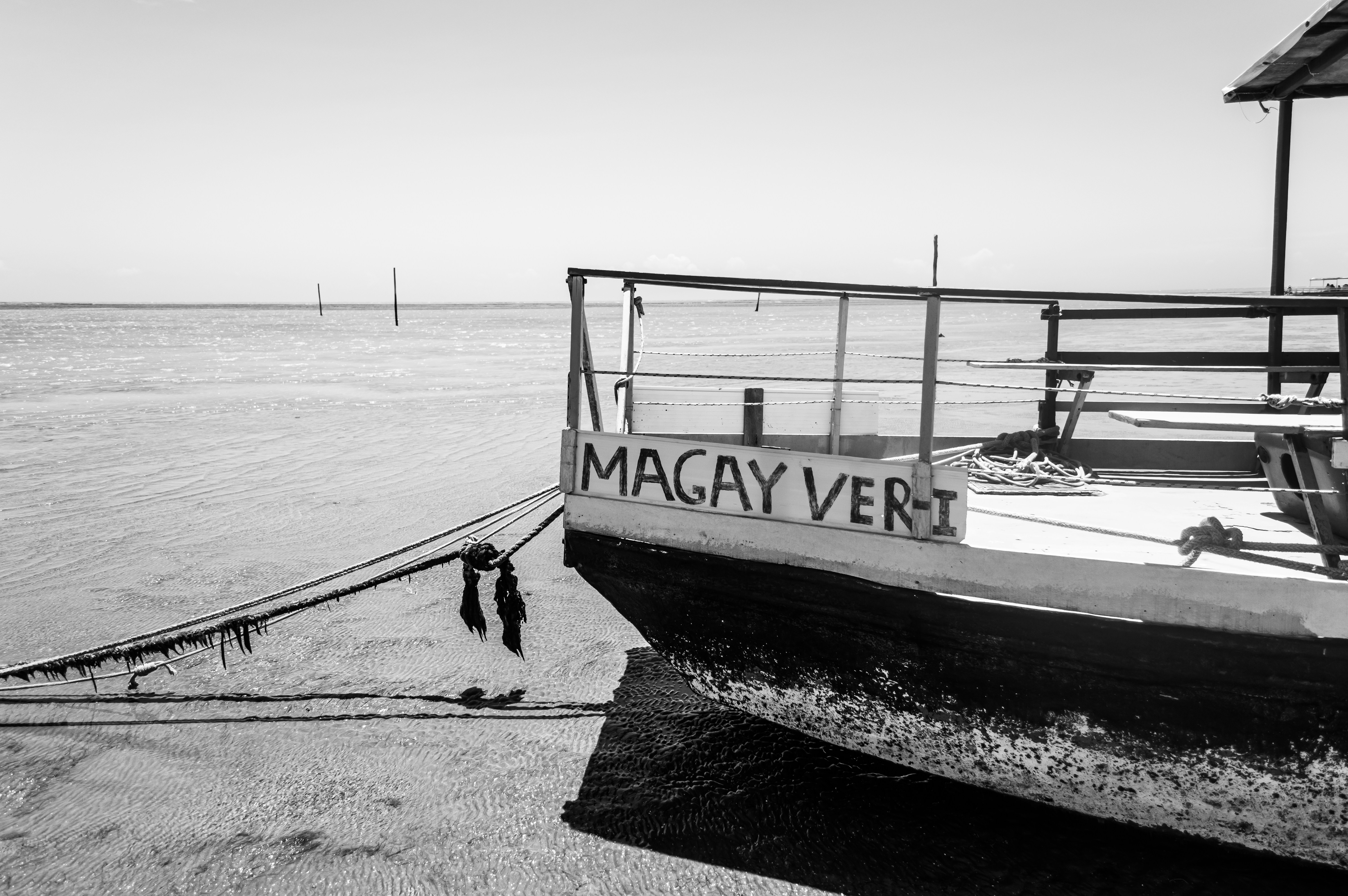 a black and white photo of a boat on the beach