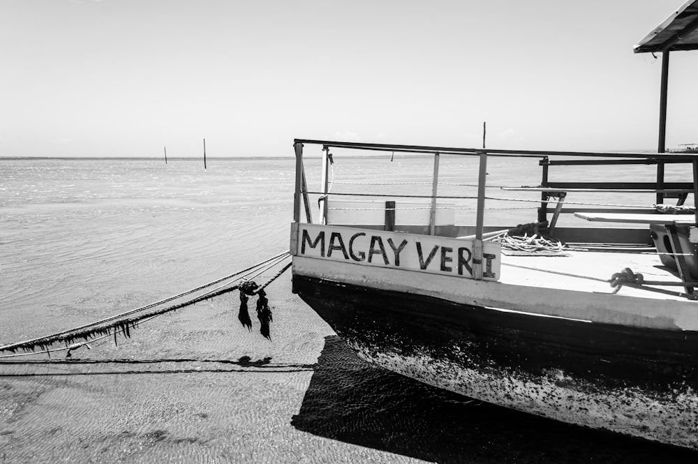 a black and white photo of a boat on the beach