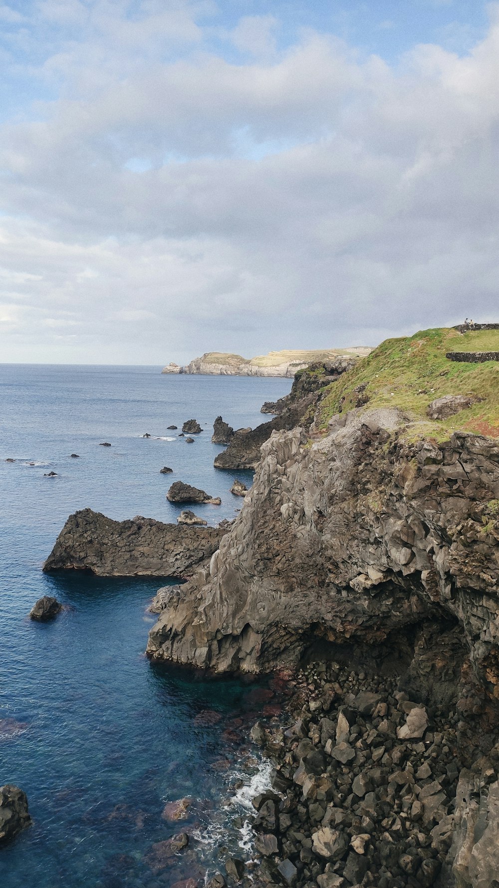 a large body of water sitting next to a lush green hillside