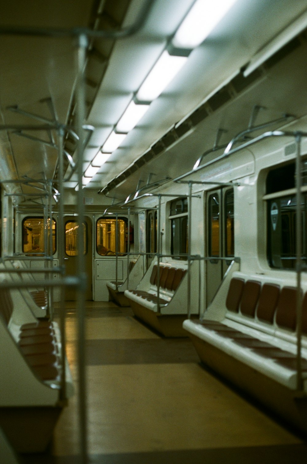 a subway car with empty seats and railings