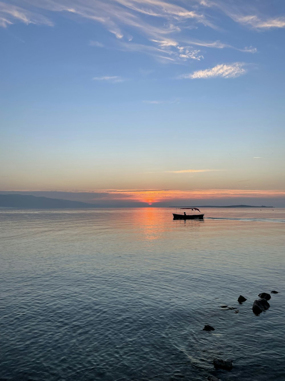 a small boat floating on top of a large body of water