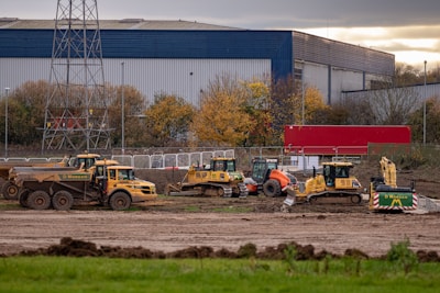 a group of construction vehicles parked in front of a factory