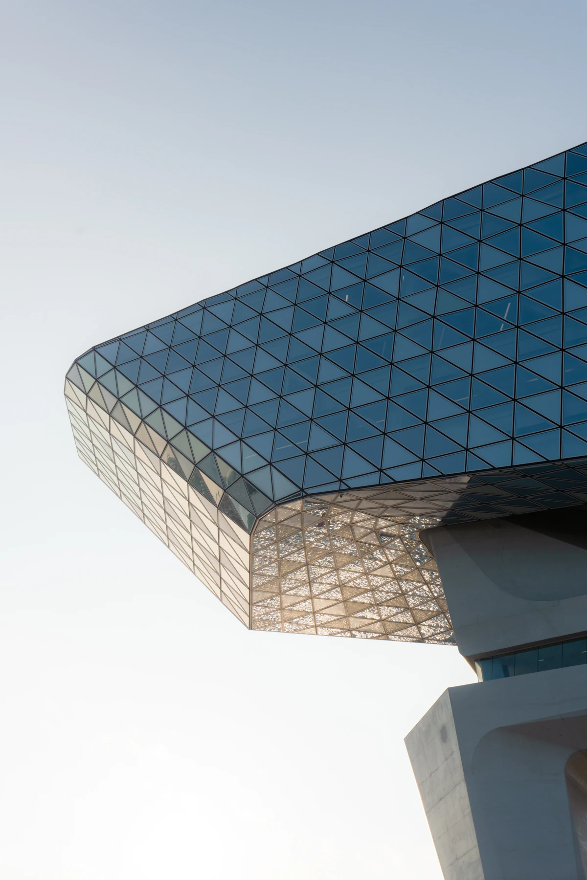 Modern commercial office building exterior viewed from below against a clear sky