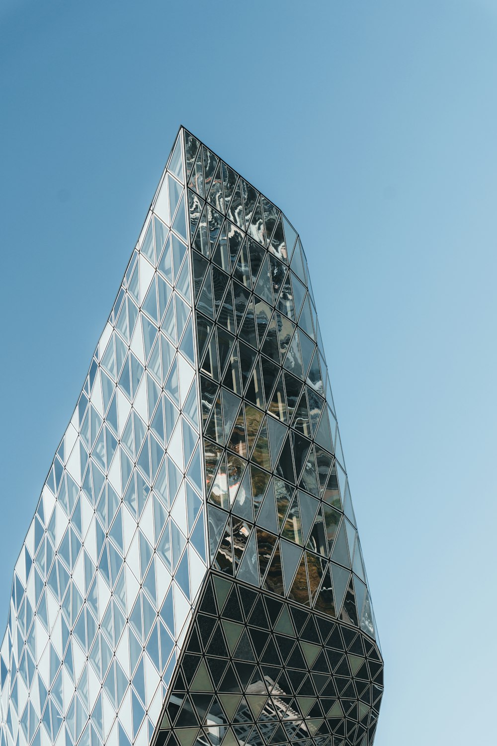 a very tall glass building with a sky background