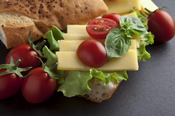 A sandwich with cheese, tomatoes, and lettuce