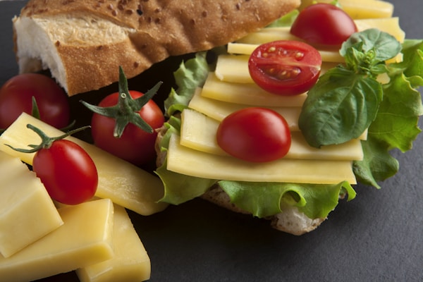 A sandwich with cheese, tomatoes, lettuce and cheese