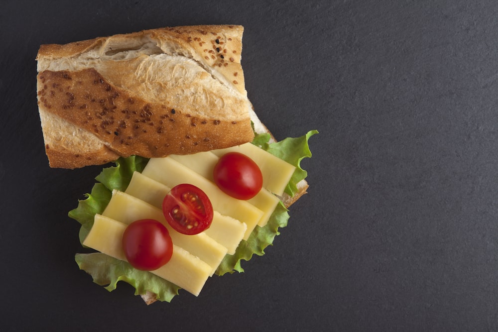 a sandwich with cheese, tomatoes and lettuce