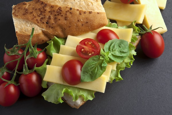 A sandwich with lettuce, tomatoes, cheese and tomatoes