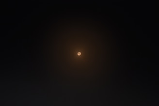 A peaceful, softly glowing circle of light surrounded by subtle spiritual symbols representing chakra energy.