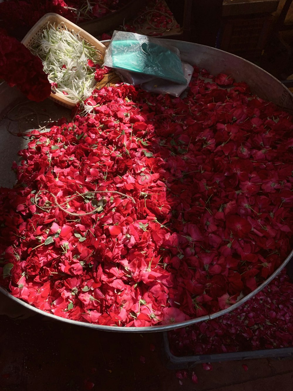 a large metal bowl filled with lots of red flowers