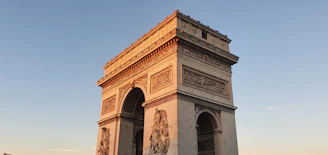 A sepia-toned photograph of the monument under early morning light, showing its intricate stonework.