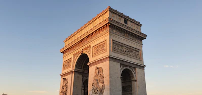 A sepia-toned photograph of the monument under early morning light, showing its intricate stonework.